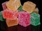 Cubes of jelly on a black reflective background