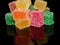 Cubes of jelly on a black reflective background