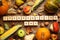 Cubes with phrase THANKSGIVING DAY, autumn fruits and vegetables on background, flat lay. Happy holiday