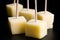 Cubes of yellow cheese on toothpicks.