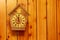 Cuckoo clock with Roman numerals on a wooden wall. Place for your text