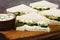 Cucumber cream cheese sandwiches closeup on the wooden board. Horizontal