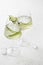 Cucumber infused detox water in glasses with ice. Homemade flavored lemonade on white gray background close up with text