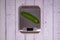 An cucumber lies on a digital kitchen scale on a table of light boards