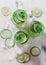 Cucumber and lime alcoholic cocktails on white marble surface