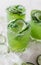Cucumber and lime alcoholic cocktails on white marble surface