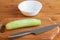 Cucumber, plate and knife on a cutting board.