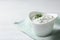 Cucumber sauce in ceramic bowl on wooden background, space for text