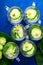 Cucumber water in six little mason glass jar on blue background. Rustic. Top view. Detox.