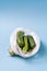 Cucumbers in plastic bag on blue background. Stop using artificial food storage bags concept