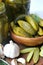 Cucumbers in a wooden bowl, spices for pickling and jars of pickled cucumbers on the table