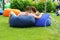 Cuddling couple on bean bags enjoy picnic in the park