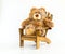Cuddly teddy bear in a brown wooden chair isolated on white