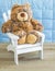 Cuddly teddy bear in a white wooden chair