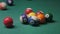 The cue ball breaks with spaced balls.. game of billiards on the green cloth. Billiard balls with numbers on the billiard table