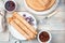 Culinary background with pancakes with filling and berries on a light wooden background.