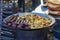 Culinary buffet with healthy takeaway food - delicious sausages and potatoes at a street cooking fair, festival, event.
