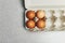 Culinary class in a kitchen. Four tinted brown chicken eggs in an open carton box on the table ready for cooking