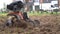 Cultivator blades plowing soil at townhouse yard. Gimbal movement closeup shot.