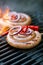 cumberland sausage, spiral pork sausage on bbq grill with flame,
