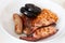 Cumberland sausages, bacon, baked beans and black pudding in a white bowl