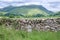 Cumbrian hills with an old-style milestone and drystone wall in the foreground, Cumbria, UK