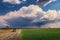 A cumulonimbus storm cloud over the fields and convective rainfall.