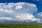 Cumulonimbus thunderstorm cloud and green grass field