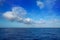 Cumulus clouds in blue sky over water horizon