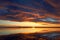 Cumulus sunset clouds with sun setting down. Fiery orange sunset sky. Beautiful sky.