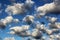 Cumulus white puffy fluffy clouds against deep blue sky
