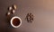 Cup of acorn coffee, acorns and autumn oak leaves on a brown background