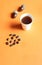 Cup of acorn coffee, acorns and coffee beans on a orange background