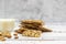 Cup of almond milk and stack of whole grain biscuits on light background. With copy space