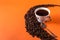 Cup of aromatic coffee and coffee beans on an orange trendy background with space for text