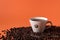 Cup of aromatic coffee and coffee beans on an orange trendy background with space for text