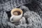 A cup of aromatic coffee wrapped in wool snod
