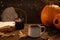 Cup of aromatic tea, candle, pumpkins and autumn leaves on wooden table indoors. Space for text