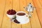 Cup with beverage, dry berries of briar in bowl, small samovar on table