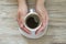 Cup of black aroma coffee in womans hand on wooden background