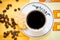 A cup of black coffee, crackers and coffee beans