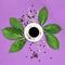 Cup of black coffee with flowers on purple coloured art background. Good Morning coffee floral setup.