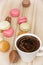 Cup of black coffee with french colorful macarons, sweet delight