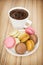 Cup of black coffee with french colorful macarons, sweet delight