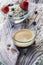 Cup of black coffee and glass bowl with flakes, berries and one spoon