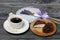 A cup of black coffee on a saucer. Nearby zephyr in chocolate, cut in half, a slice is visible. Zephyr in the form of a rose.