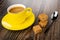 Cup with black coffee in saucer, pieces of creamy toffee with peanut, spoon on wooden table