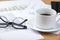 Cup of black coffee and spectacles on an accountant\'s desk