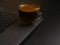 A cup of black coffee stands on a laptop on a black background.Dimmed lights. Space for text