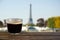 Cup of black coffee on wooden table with view on Eiffel tower in Paris